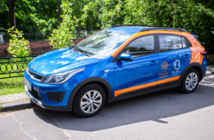 Blue and Orange car parked displaying company logo